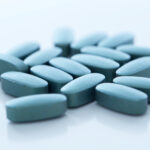 Closeup picture of blue pills over a white background