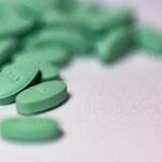 A selection focus shot of green pills on a white surface